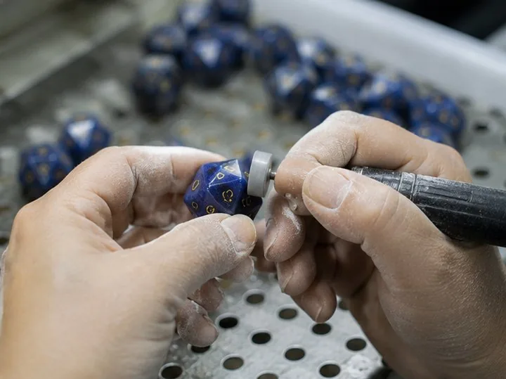 CuiShen craftsperson hand-finishing a lapis lazuli D20